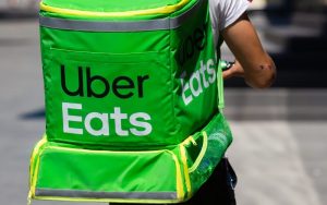 Entregador de costas com pacote do UberEats
